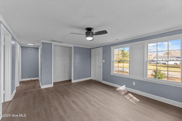 unfurnished room featuring hardwood / wood-style flooring, ornamental molding, ceiling fan, and a textured ceiling