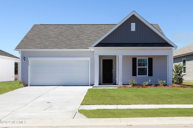 view of front of home featuring a porch, a garage, and a front lawn