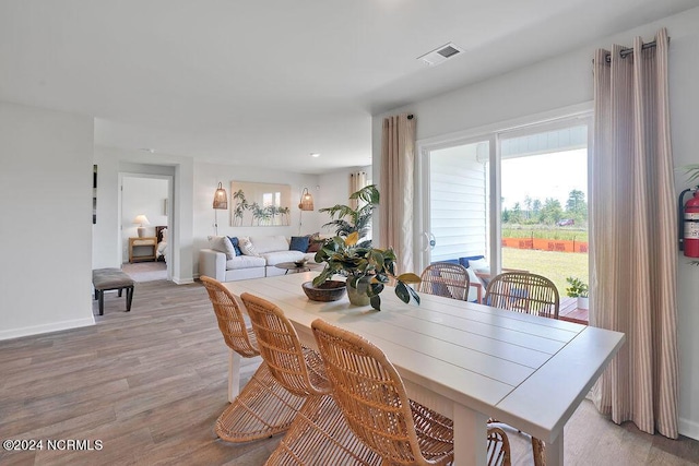 dining space with baseboards, visible vents, and light wood-style floors