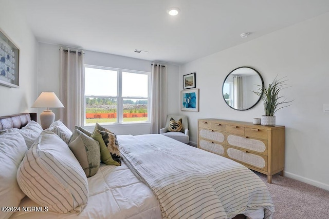 bedroom featuring baseboards, visible vents, and light colored carpet