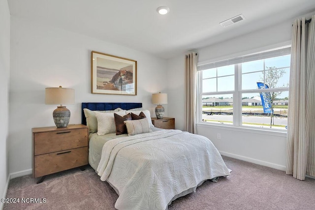 carpeted bedroom featuring visible vents and baseboards