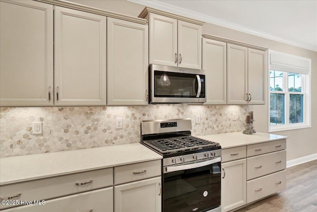 kitchen with backsplash, crown molding, cream cabinets, appliances with stainless steel finishes, and light wood-type flooring