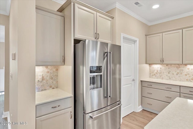 kitchen featuring light wood-type flooring, backsplash, high end fridge, and crown molding