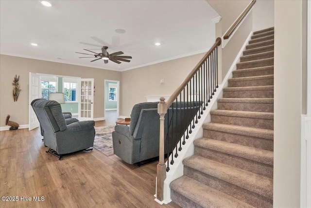 living room featuring ceiling fan, crown molding, and wood-type flooring