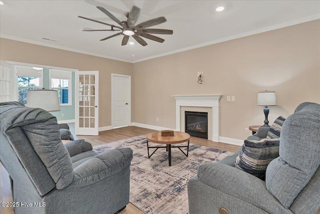 living room with ceiling fan, crown molding, french doors, and light wood-type flooring