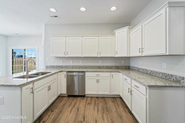 kitchen with kitchen peninsula, dark wood-type flooring, stainless steel dishwasher, white cabinets, and sink