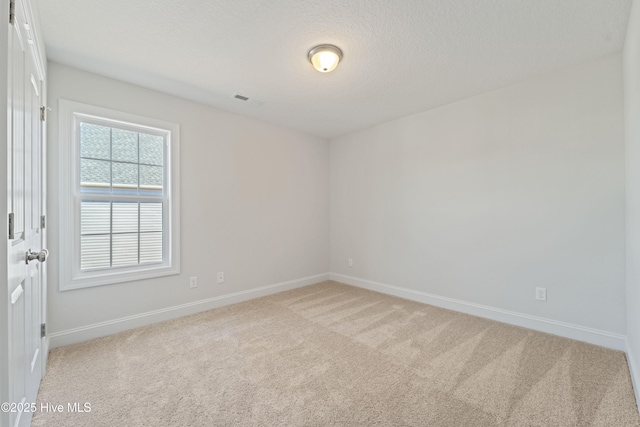 carpeted spare room featuring a textured ceiling