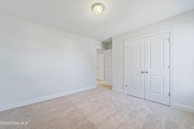 unfurnished bedroom with light colored carpet and a closet