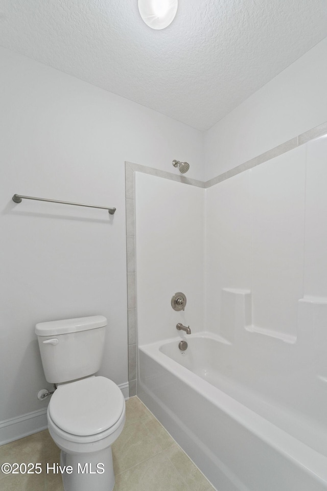 bathroom featuring a textured ceiling, toilet,  shower combination, and tile patterned flooring