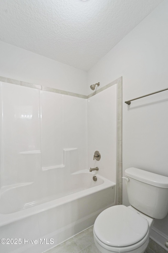 bathroom with tub / shower combination, a textured ceiling, toilet, and tile patterned flooring