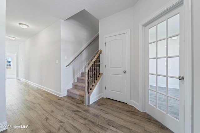 stairs with a wealth of natural light and wood-type flooring