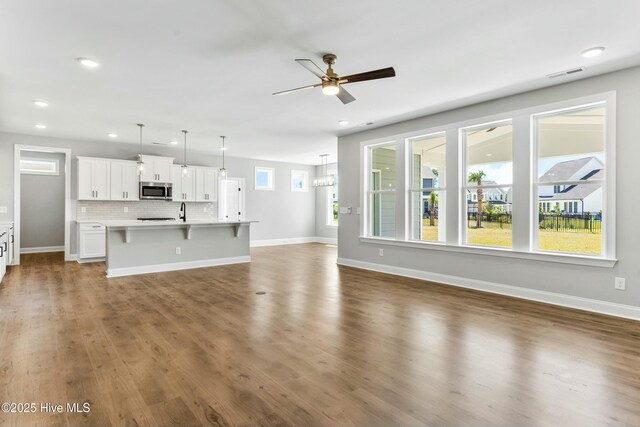 kitchen featuring sink, pendant lighting, a healthy amount of sunlight, stainless steel dishwasher, and a kitchen island with sink