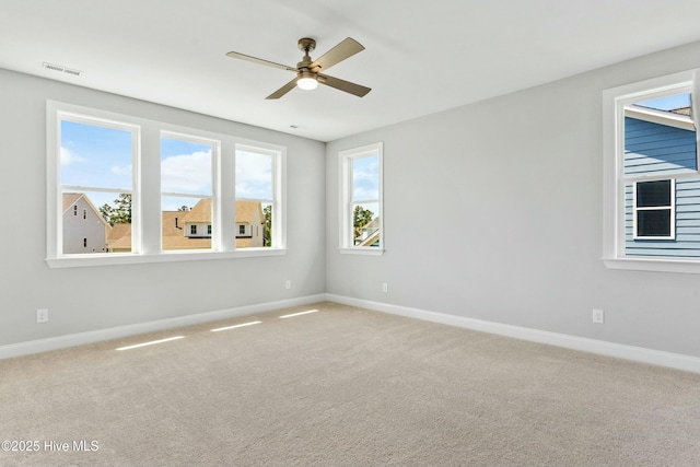 carpeted spare room featuring ceiling fan