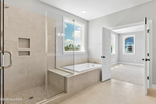 bathroom featuring a healthy amount of sunlight, independent shower and bath, and tile patterned flooring