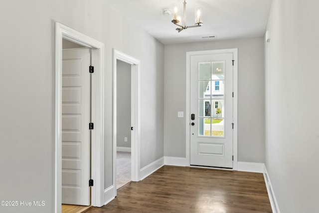 entryway with an inviting chandelier and dark hardwood / wood-style flooring