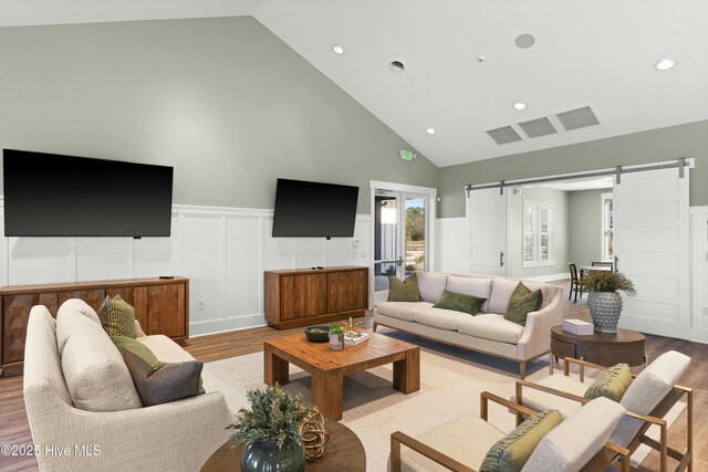 dining space featuring high vaulted ceiling and light hardwood / wood-style flooring