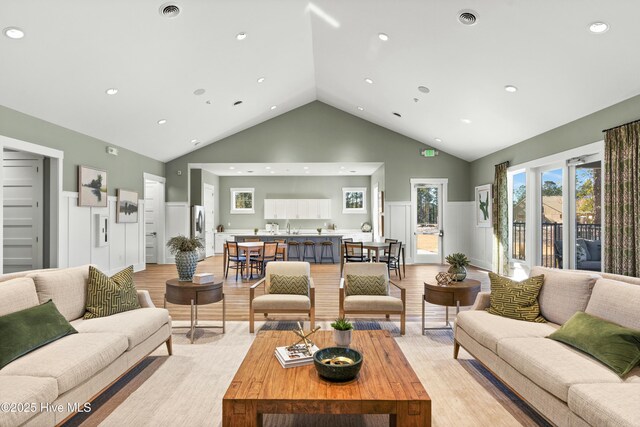 dining space featuring light wood-type flooring and high vaulted ceiling