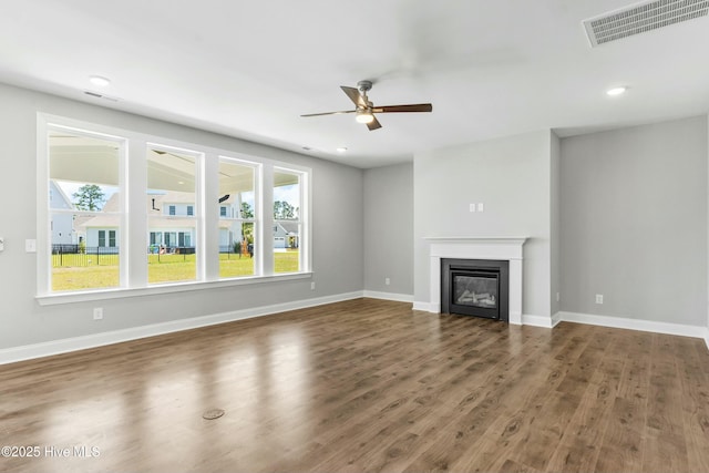 unfurnished living room with dark hardwood / wood-style floors and ceiling fan