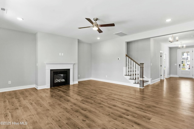 unfurnished living room with hardwood / wood-style flooring and ceiling fan with notable chandelier