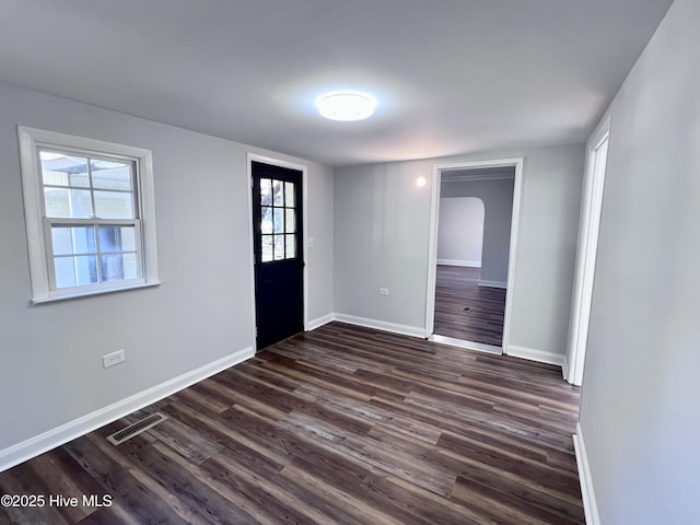 empty room featuring dark hardwood / wood-style flooring and a healthy amount of sunlight