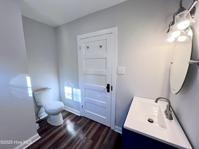 bathroom featuring toilet, vanity, and wood-type flooring