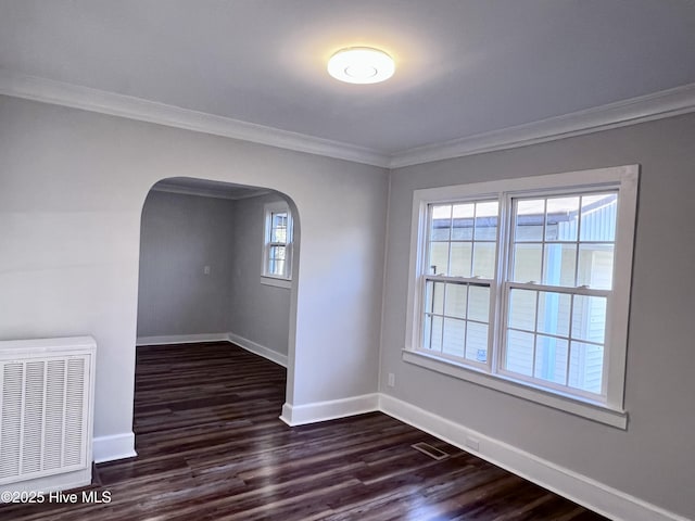 unfurnished room featuring dark wood-type flooring and crown molding