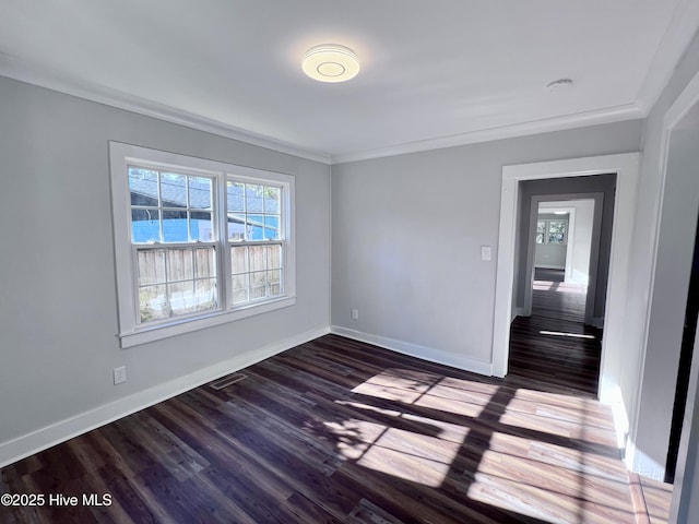 spare room featuring dark hardwood / wood-style flooring and ornamental molding