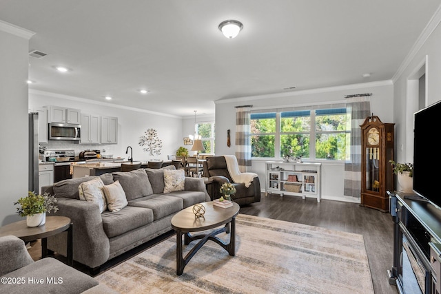 living room with a wealth of natural light, crown molding, and dark hardwood / wood-style floors