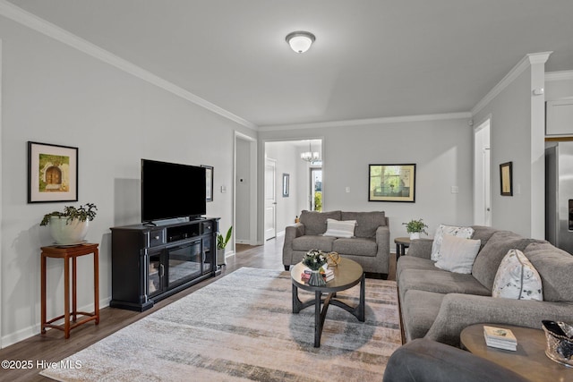 living room with dark hardwood / wood-style flooring, an inviting chandelier, and ornamental molding