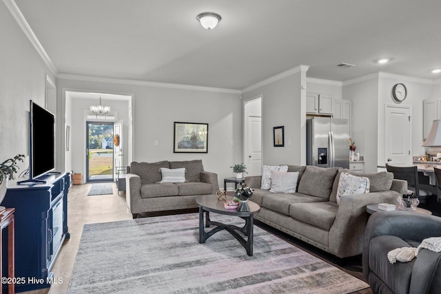 living room with ornamental molding and a chandelier