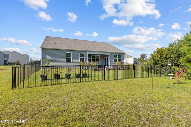 rear view of property featuring a lawn