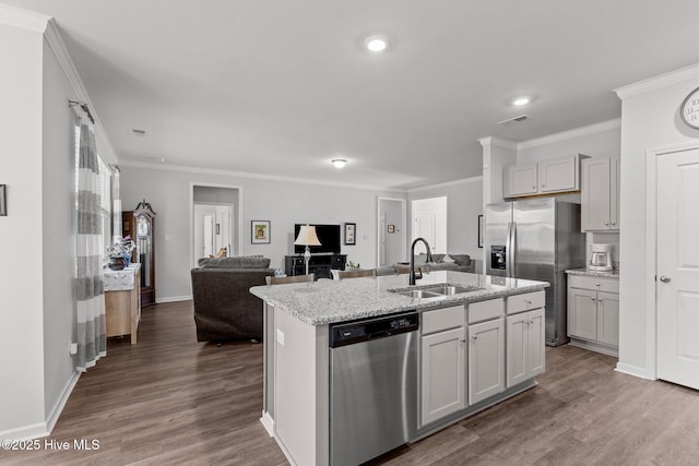 kitchen featuring hardwood / wood-style flooring, sink, stainless steel appliances, and a kitchen island with sink