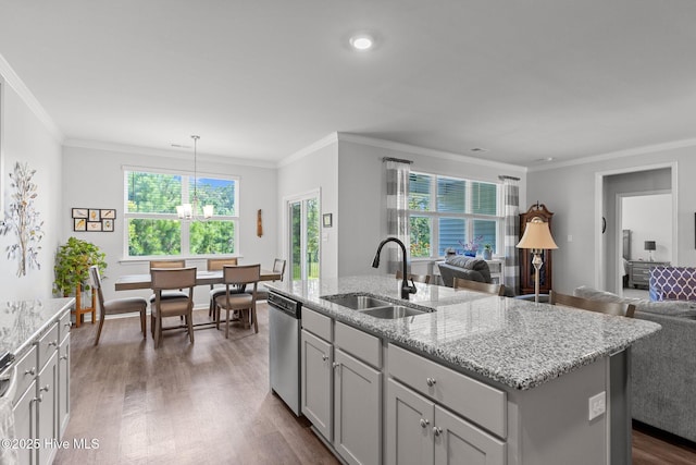 kitchen featuring sink, dishwasher, hanging light fixtures, a kitchen island with sink, and ornamental molding