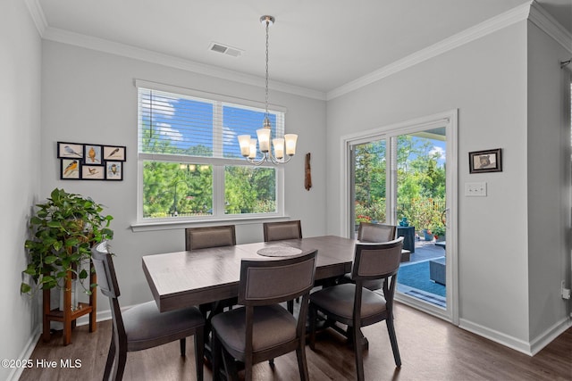 dining room with dark hardwood / wood-style floors, crown molding, and a notable chandelier