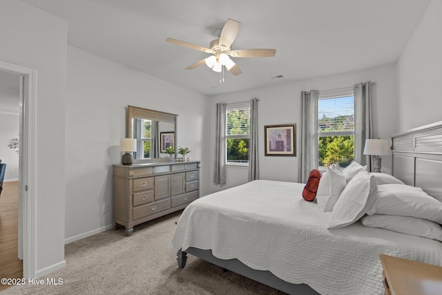 carpeted bedroom with multiple windows and ceiling fan