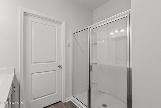 bathroom with wood-type flooring, vanity, and walk in shower