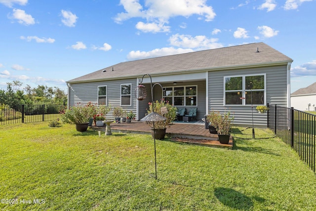 rear view of property featuring a deck and a lawn