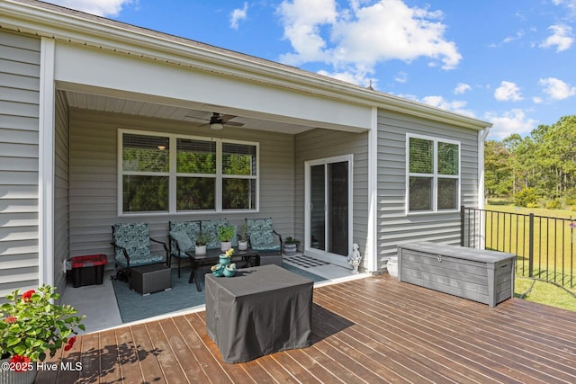 wooden deck featuring an outdoor living space and ceiling fan