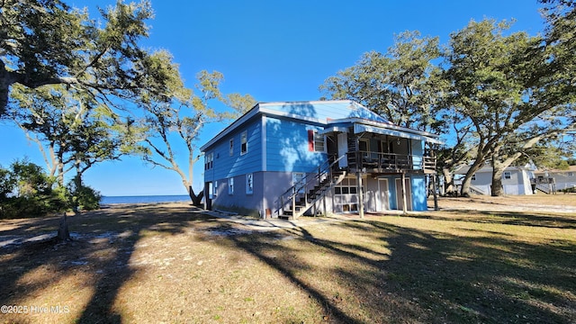 exterior space with a water view and a front lawn