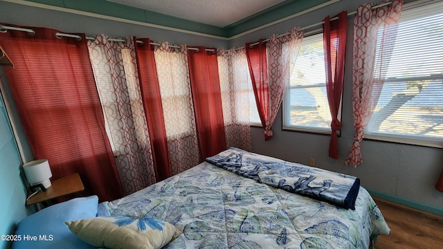 bedroom with hardwood / wood-style floors and a textured ceiling