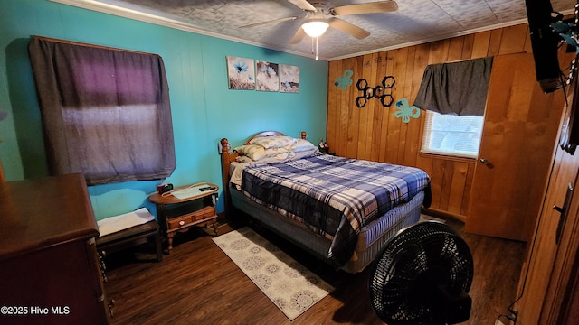 bedroom with ceiling fan, wooden walls, crown molding, and hardwood / wood-style flooring