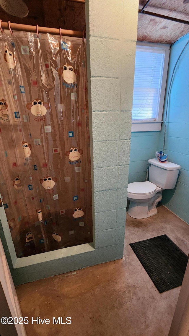 bathroom with concrete floors and toilet