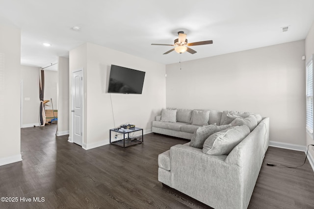 living room featuring dark wood-type flooring and ceiling fan