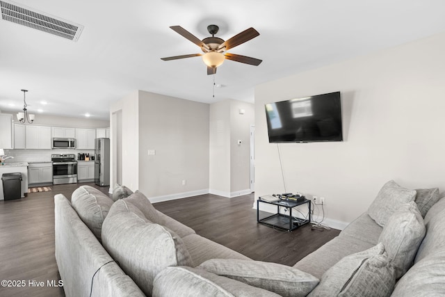 living room featuring sink, dark wood-type flooring, and ceiling fan