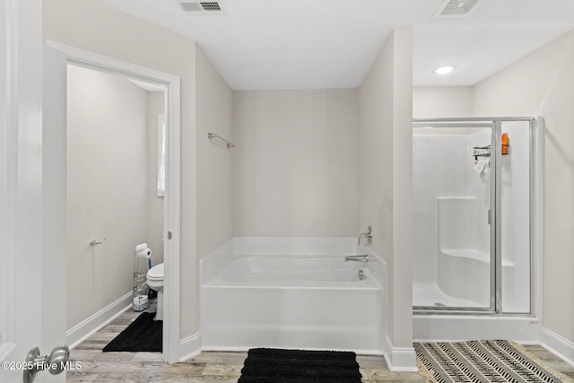 bathroom featuring wood-type flooring, toilet, and separate shower and tub