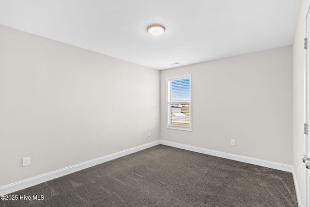 unfurnished room featuring dark colored carpet