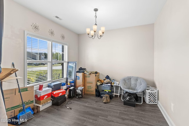 miscellaneous room featuring an inviting chandelier and hardwood / wood-style floors