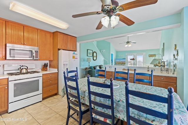 kitchen with ceiling fan, light tile patterned flooring, and white appliances