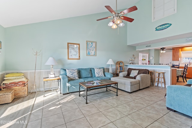 tiled living room featuring ceiling fan and high vaulted ceiling