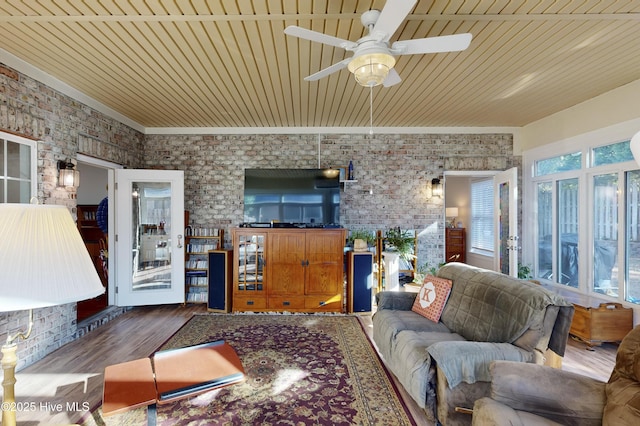 living room featuring hardwood / wood-style flooring, ceiling fan, wood ceiling, and brick wall